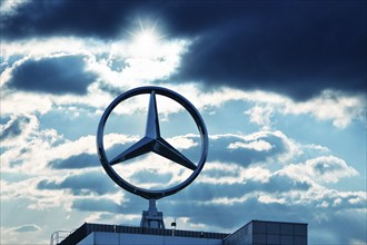 Symbolic image, Dark clouds at Mercedes, Mercedes logo on a building surrounded by dramatic cloud