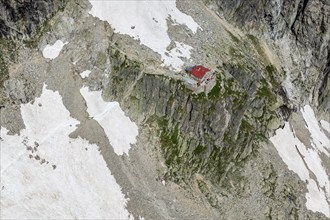 Aerial view of mountain hut Cabane de l'A Neuve, located on a steep rock formation, near La Fouly,