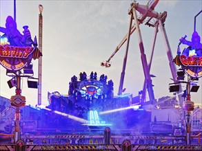 People on the illuminated carousel Mr Gravity in the evening, Cranger Kirmes, Herne, Ruhr area,