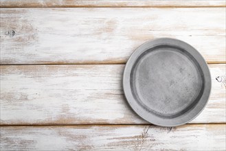 Empty gray ceramic plate on white wooden background. Top view, copy space, flat lay