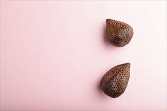 Salak or snake fruit on pink pastel background. Top view, flat lay, copy space. Tropical, healthy