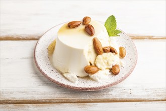 Ricotta cheese with honey and almonds on white wooden background. side view, close up