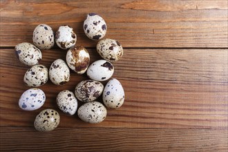 Raw quail eggs on a brown wooden background. top view with copy space