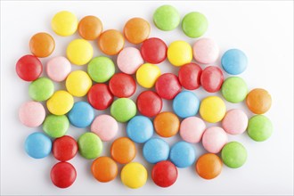 Colorful multicolored chocolate candy dragees isolated on white background. Top view, close up