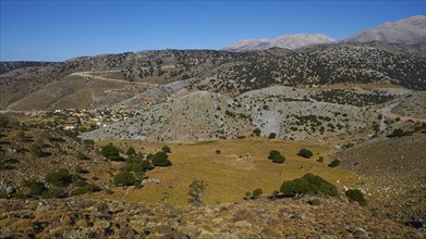 Plateau, panorama of a rural landscape with village and mountains in the background, Lefka Ori,