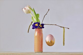 Picturesque still life with flowers and moving Easter egg, Germany, Europe