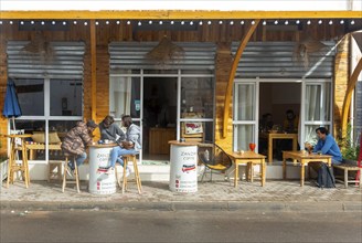 People sitting outside Zanzan cafe in town centre of Mirleft, southern Morocco, North Africa