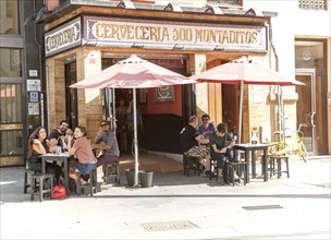 Happy people waving outside traditional cerveceria bar in central Seville, Spain, Europe