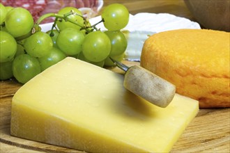 Cheese platter with various types of soft cheese and grapes