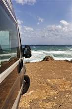 Campervan by the sea, motorhome parked on the rocky coast, coastline near La Isleta del Moro,