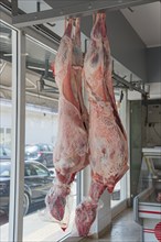 Two sheep hanging on meat hooks, light coming in through the window, Gastouni, Elis, Peloponnese,