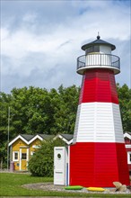 Colourful lobster shacks and lighthouse in the outdoor area of the museum with different themed