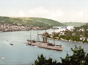 The RMS Dunottar Castle, a Royal Mail ship on the River Dart, Devon, England. The town of Dartmouth