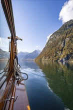 A trumpet is played on the echo wall of a tourist boat, Königssee, autumnal mountain landscape