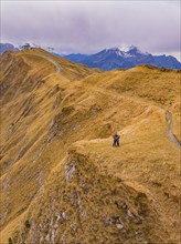 Couple on a mountain path with a wide view in autumnal surroundings, Alpen Tower, Switzerland,