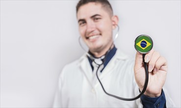 Brazil National Healthcare concept. Smiling doctor showing stethoscope with Brazil flag