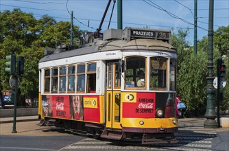 Yellow and red tram with advertising runs on rails in daylight, tram, Carros eléctricos de Lisboa,