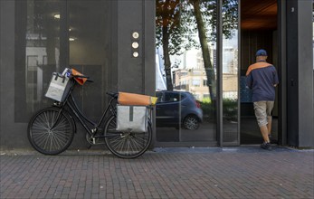 Dutch Post deliverer, with bicycle, in Rotterdam, Netherlands