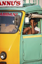 Young man in a yellow-green cargo rickshaw, Fort Cochin, Kochi, Kerala, South India, India, Asia