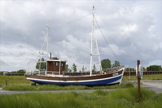 Fishing boat in front of the Ocean wave adventure pool, Norddeich, East Frisia, Lower Saxony,