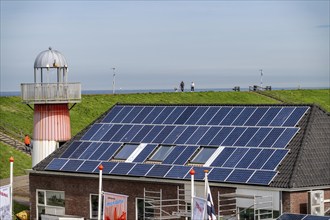 Solar modules on roofs, on the roof of a building on the dyke, North Sea coast, in Zeeland,