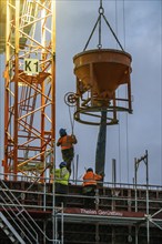 Concrete work, at dusk, on a large construction site building a residential and commercial complex,