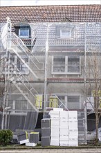 Energetic refurbishment of residential buildings, older apartment building is scaffolded, gets