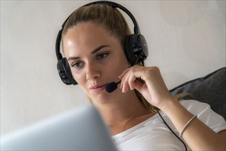 Young student learns at home, online, in conversation with other students