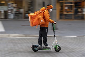 Delivery service Lieferando.de, delivery courier with e-scooter in the city centre, Rathenaustraße,