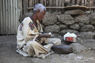 Amhara region, small farm, woman sitting on the ground plucking cotton, Ethiopia, Africa