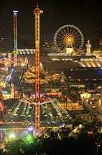 View over the Wies'n at night with illuminated carousel, Ferris wheel, stalls, beer tents and