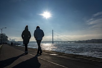 Dense fog is slowly lifting, riverside promenade on the Rhine near Düsseldorf, in front the