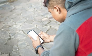 Guy sitting with cell phone messaging