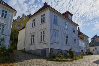 A quiet cobbled street in Bergen's old town centre, with traditional houses and sunny summer