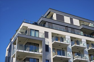 Modern residential building with several balconies and a façade under a clear blue sky, Molde,