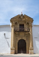 Historic stone entrance gate with decorated coat of arms and balcony in Spanish town, Plaza de