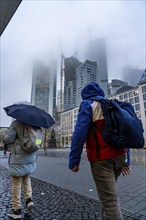 Rainy weather, freezing rain, Goetheplatz, high-rise skyline in clouds, passers-by hurrying through