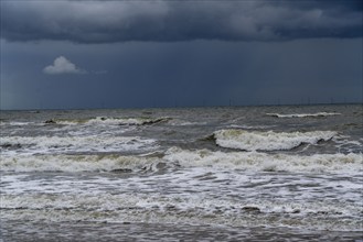 Beach, dark storm clouds, choppy sea, autumn on the North Sea in North Holland, between the towns