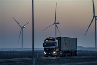 Lorry on the road to Euromax Terminal Rotterdam, ENECO wind farm on the dike around the port of