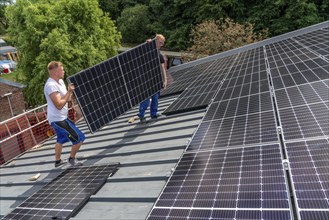 Installation of solar modules on the roof of a barn on a farm, over 210 photovoltaic modules are