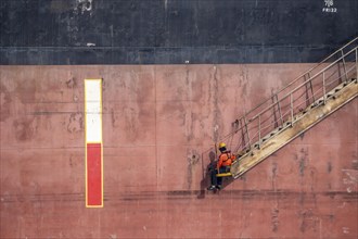 Sailor, waiting, on a leash, for the pilot, on a companionway, drop deck, ship's stairs, cargo ship