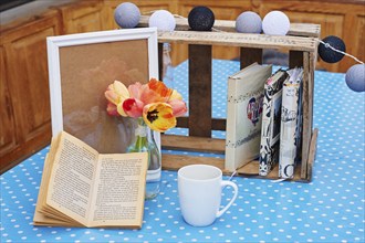 Tulips (Tulipa) beside books and a coffeecup, Germany, Europe