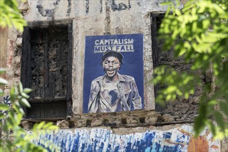 Poster critical of capitalism with a portrait of a coloured man in Exarchia, district of the