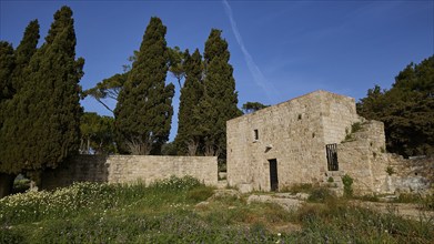 Byzantine fortress, Ancient stone buildings and trees under a blue sky, Filerimos, hill not far