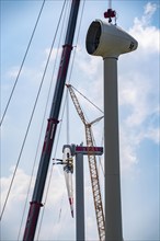 Erection of an Enercon E-160 wind turbine, rear, assembly of the first blade, 4 turbines with a