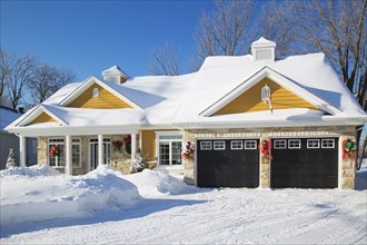 Beige and tan natural cut stone with yellow wood cladding, white and black trim country style house