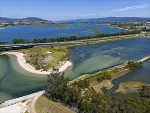 A natural area criss-crossed by rivers and islands with blue water and mountains in the background,