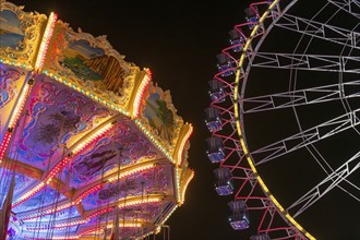 A funfair at night with illuminated chain carousel and Ferris wheel, Europa Rad, rides, wave