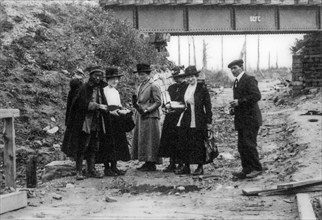 Belgian WWI battlefield tourists buying souvenirs from labourer of Chinese Labour Corps, CLC during