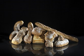 Assortment of different loaves of bread on black background